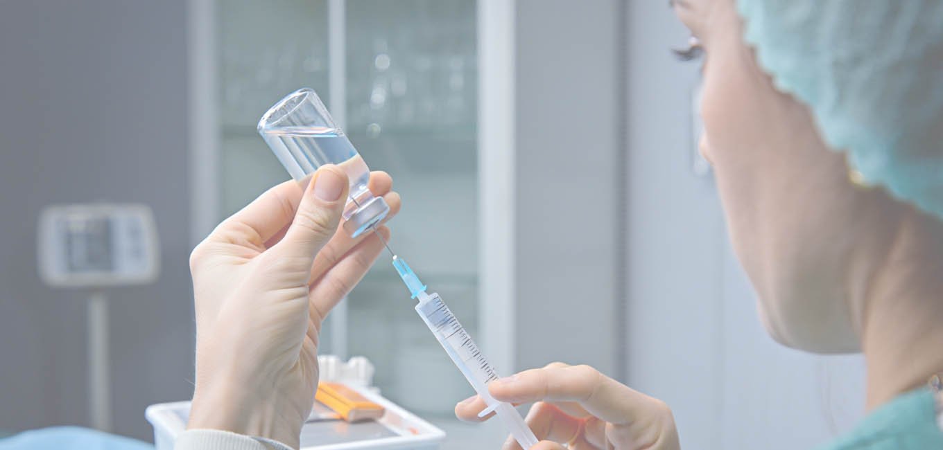 Женщина-санитар набирает лекарство